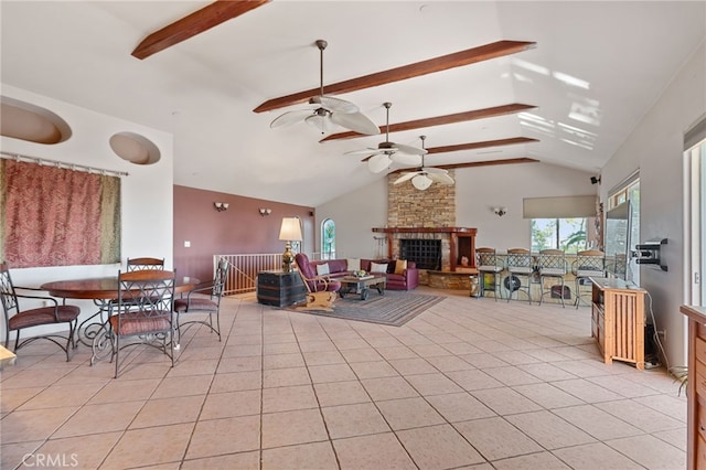 living room featuring light tile patterned floors, a stone fireplace, ceiling fan, high vaulted ceiling, and beamed ceiling