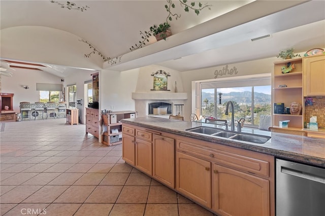 kitchen with ceiling fan, light tile patterned flooring, lofted ceiling, stainless steel dishwasher, and sink