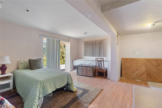 bedroom featuring hardwood / wood-style floors and beam ceiling