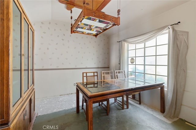 unfurnished dining area with lofted ceiling and concrete flooring