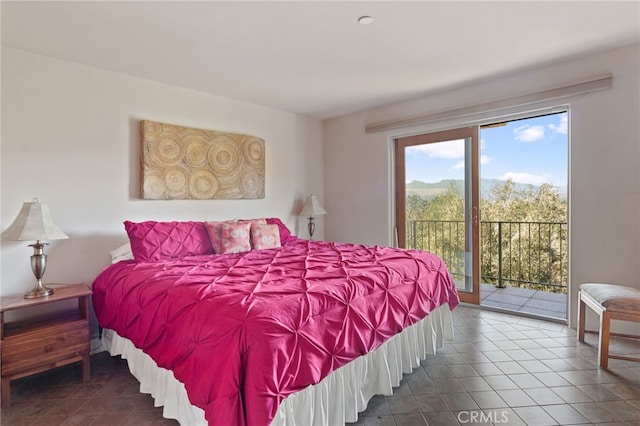 bedroom with access to outside and dark tile patterned flooring