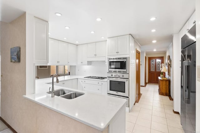 kitchen with sink, kitchen peninsula, white cabinets, and stainless steel appliances