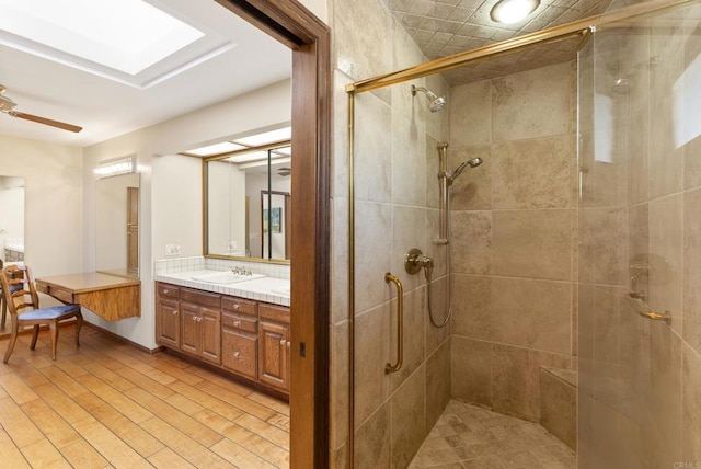 bathroom featuring ceiling fan, walk in shower, and vanity