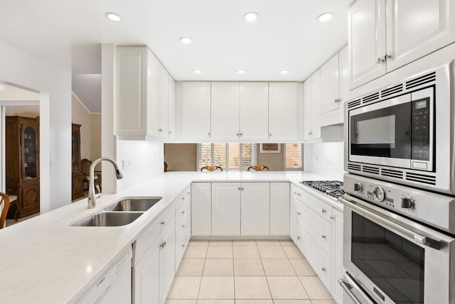 kitchen featuring white cabinetry, stainless steel appliances, kitchen peninsula, and sink