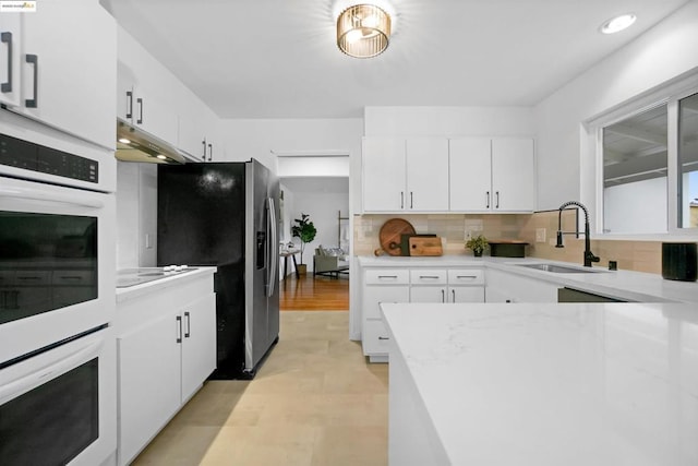 kitchen featuring tasteful backsplash, white cabinetry, sink, and stainless steel refrigerator with ice dispenser