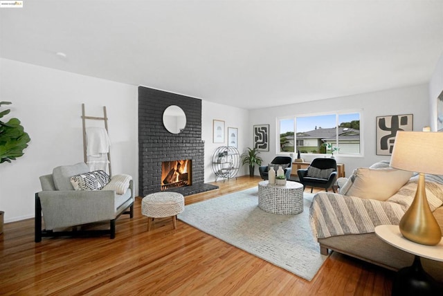 living room featuring hardwood / wood-style floors and a brick fireplace