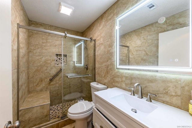 bathroom featuring toilet, vanity, and an enclosed shower