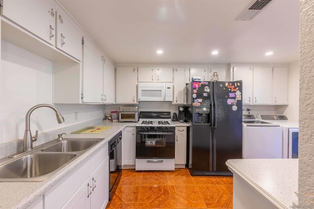 kitchen with separate washer and dryer, white cabinets, black appliances, and sink