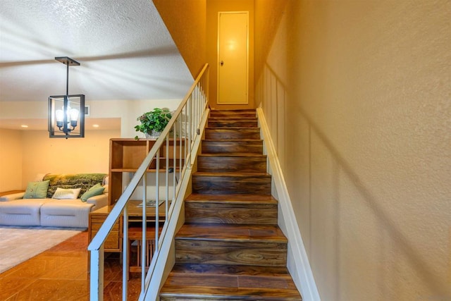 stairs featuring a notable chandelier