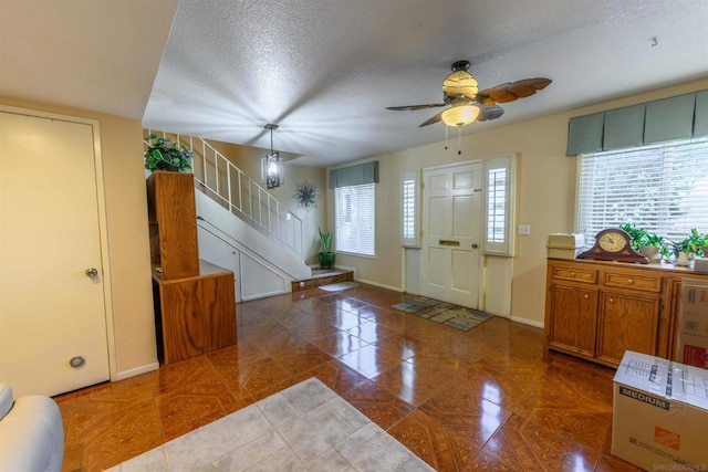 entryway featuring ceiling fan and a textured ceiling