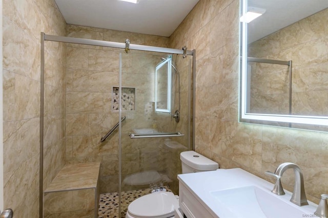 bathroom featuring a shower with shower door, tile walls, toilet, and vanity