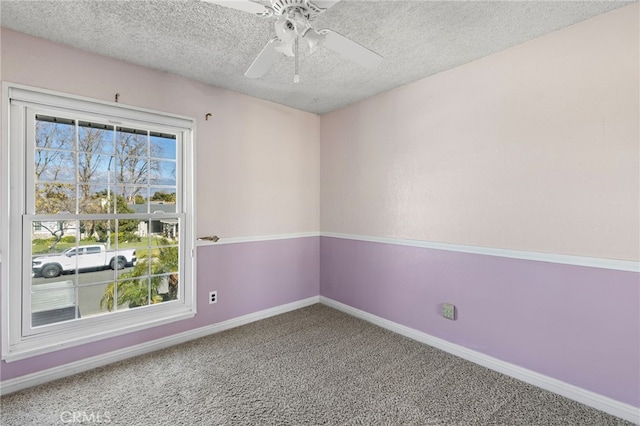 empty room with a textured ceiling, ceiling fan, and carpet