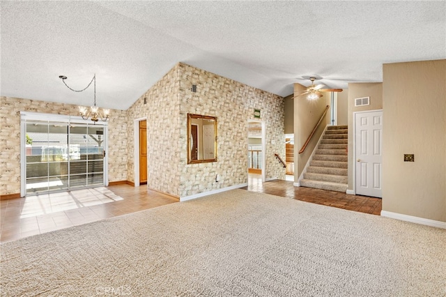 unfurnished living room featuring lofted ceiling, ceiling fan with notable chandelier, and tile patterned floors