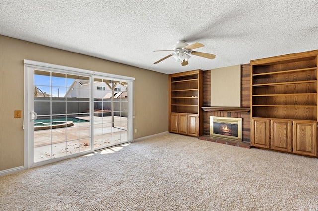 unfurnished living room featuring ceiling fan, a fireplace, carpet, and a textured ceiling