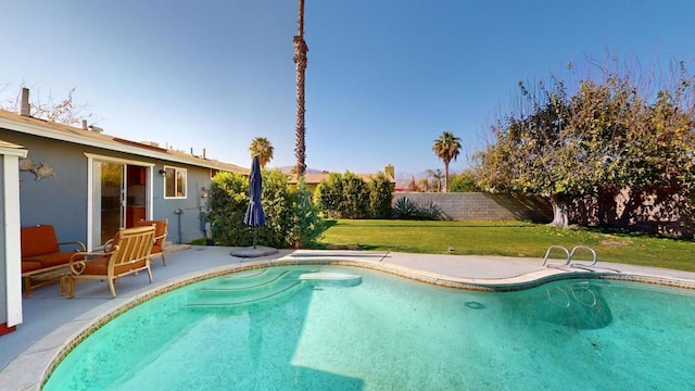 view of pool with a patio and a lawn