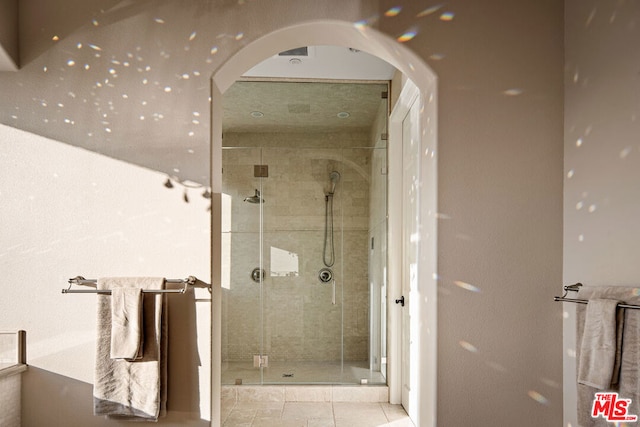 bathroom with a shower with shower door and tile patterned flooring