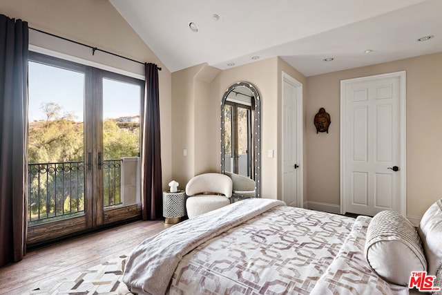 bedroom featuring lofted ceiling, access to outside, multiple windows, and light hardwood / wood-style floors