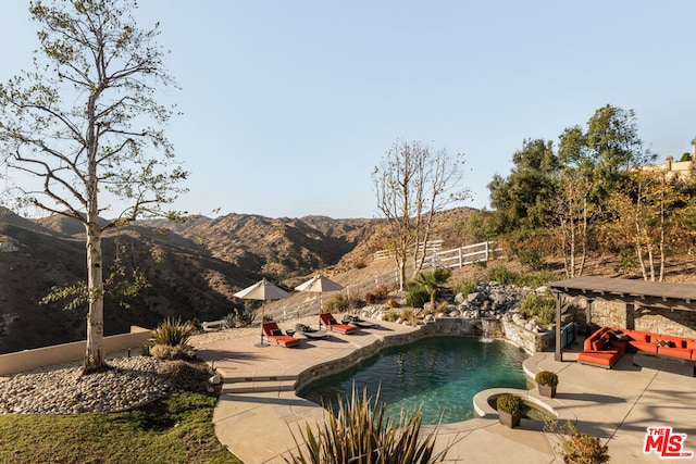 view of swimming pool with a mountain view and a patio