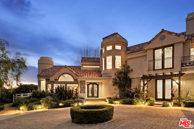 mediterranean / spanish home with french doors and a balcony