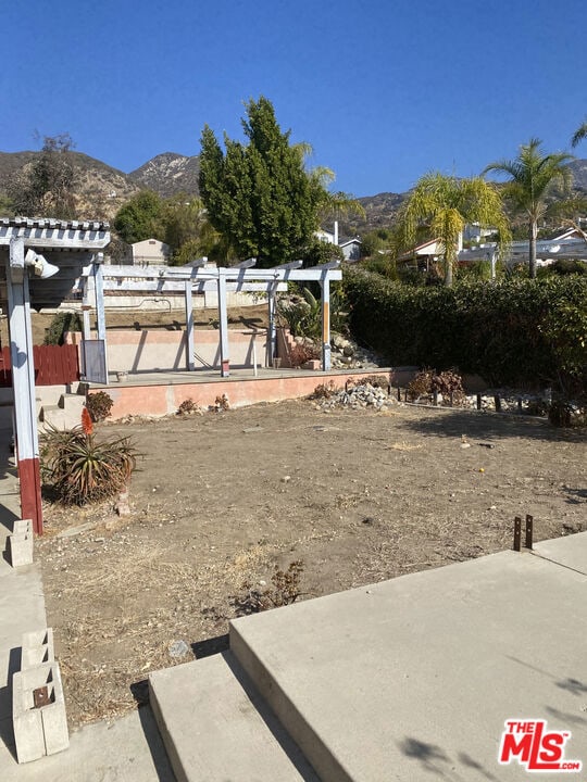 view of yard with a pergola and a mountain view