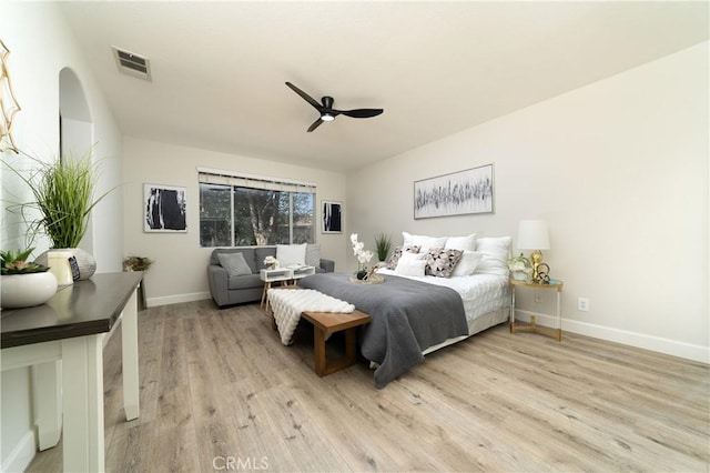 bedroom featuring a ceiling fan, baseboards, visible vents, and light wood finished floors