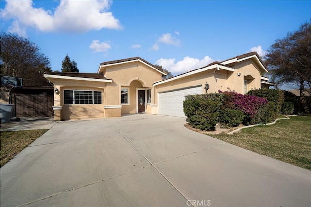 ranch-style house featuring a garage, driveway, and stucco siding