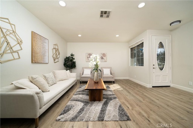 living room with baseboards, wood finished floors, visible vents, and recessed lighting