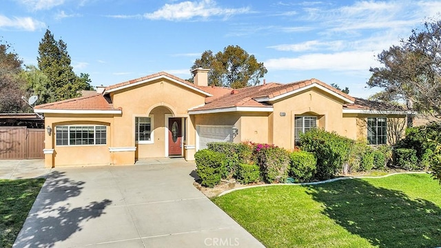 mediterranean / spanish home with fence, stucco siding, a front lawn, a garage, and a tiled roof