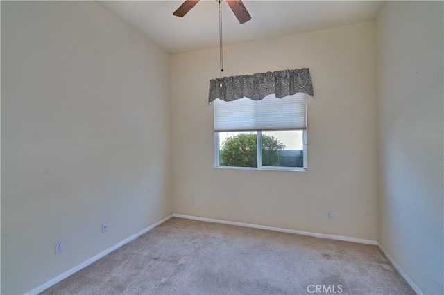 spare room with ceiling fan and light carpet