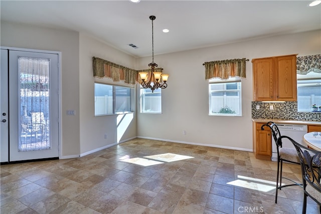 kitchen with pendant lighting, dishwasher, an inviting chandelier, and backsplash