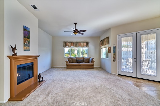 unfurnished living room featuring light colored carpet, ceiling fan, and french doors