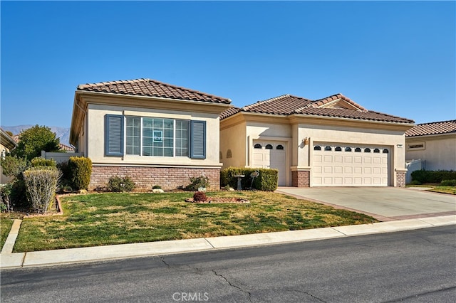 mediterranean / spanish house featuring a garage and a front yard