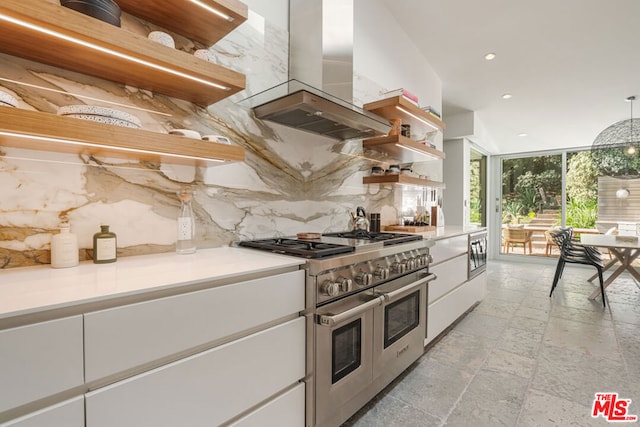 kitchen featuring tasteful backsplash, island exhaust hood, white cabinetry, appliances with stainless steel finishes, and a wall of windows