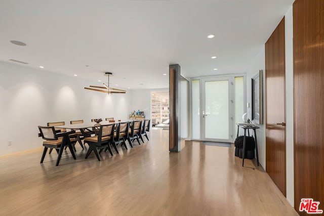 dining area with a wall of windows and light wood-type flooring