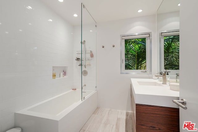 bathroom featuring tiled shower / bath combo and vanity