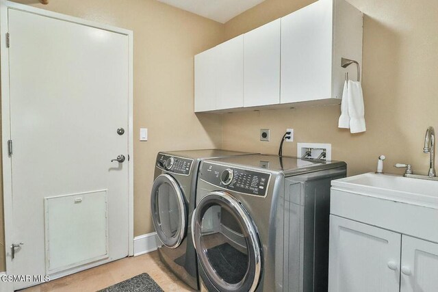 laundry area featuring cabinets, independent washer and dryer, and sink