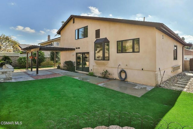 rear view of house with a pergola, a lawn, and a patio