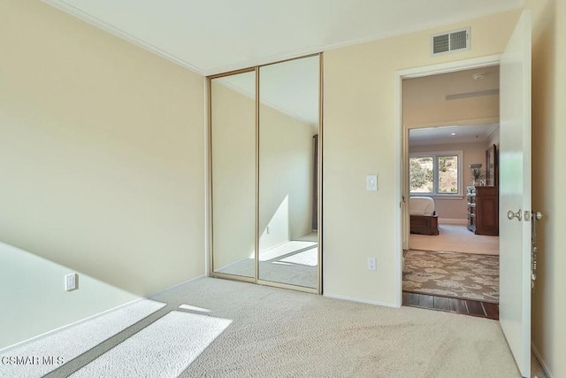 carpeted bedroom featuring a closet and ornamental molding