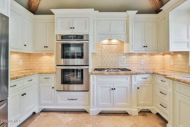 kitchen with light stone countertops, stainless steel appliances, backsplash, and beamed ceiling