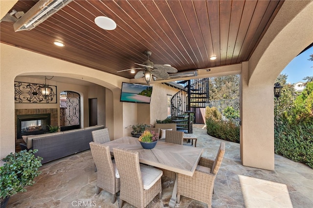 view of patio / terrace with ceiling fan and a tiled fireplace