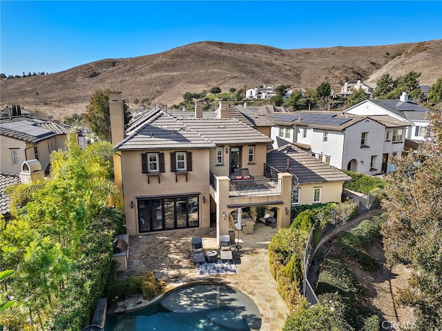 rear view of house featuring a mountain view, a patio area, and a balcony