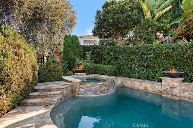 view of pool with an in ground hot tub