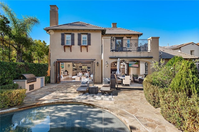 back of house with an outdoor hangout area, area for grilling, a balcony, and a patio