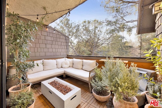 balcony featuring an outdoor living space with a fire pit