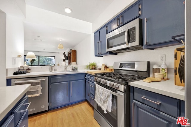 kitchen with light hardwood / wood-style floors, blue cabinetry, sink, and stainless steel appliances