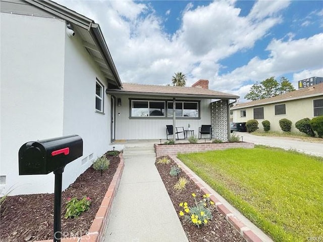 view of front of property featuring a front lawn and covered porch