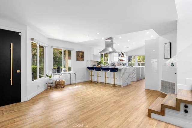 interior space featuring baseboards, light wood finished floors, a wealth of natural light, and recessed lighting