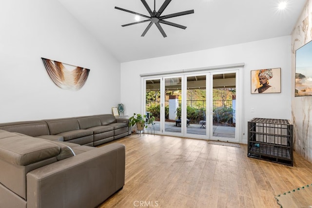 living area featuring a ceiling fan, high vaulted ceiling, and light wood-style flooring