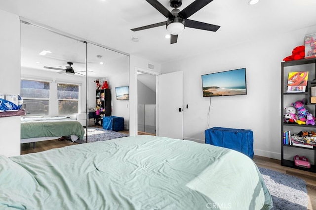 bedroom with visible vents, a closet, wood finished floors, and a ceiling fan