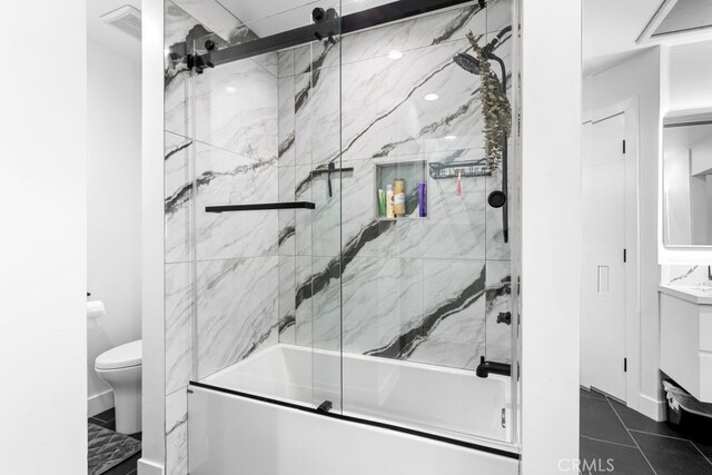 full bathroom featuring toilet, visible vents, combined bath / shower with glass door, and vanity